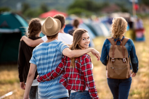 A group of friends exploring the festival area, wearing a hat